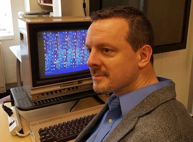 Nick Montfort in front of a Commodore 64 running one of his programs.