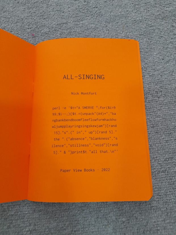 Photograph of "All-Singing", open to the title page, with source code is printed in black text.