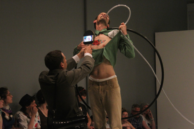 Picture of the performance, a man being force fed with a tube
