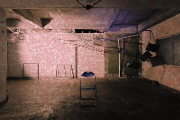 screenshot of game, showing an empty room with noise projected on its walls