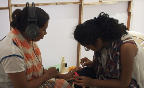 Two Brazilian women, one painting the other's nails, are recorded for the piece.