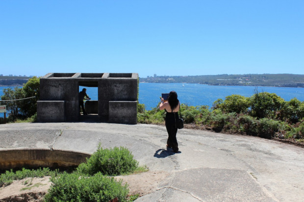 A woman looks out to the ocean beyond a bunker
